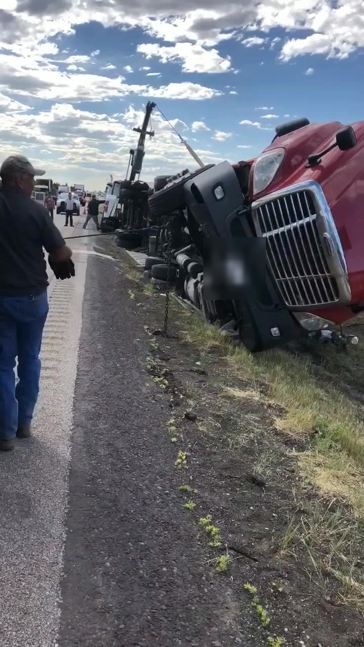 A crew member watches as the wrecker lines start lifting the tractor